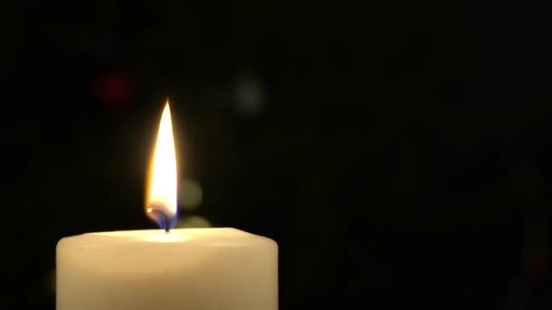 Apagando velas Primer plano de vela blanca ardiendo sobre la mesa con fondo oscuro borroso — Vídeos de Stock