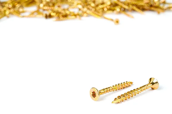 Gold screws scattered randomly on a white background. Torx yellow zinc head screws — Zdjęcie stockowe