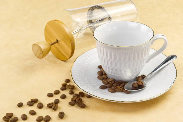 Empty white coffee cup with gold border and coffee seeds on the table. close up — Stock Fotó