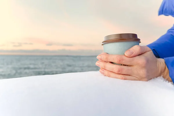 Kadın elleri karda kahve bardağını tutuyor. kahve fincanı deniz altındadır. — Stok fotoğraf