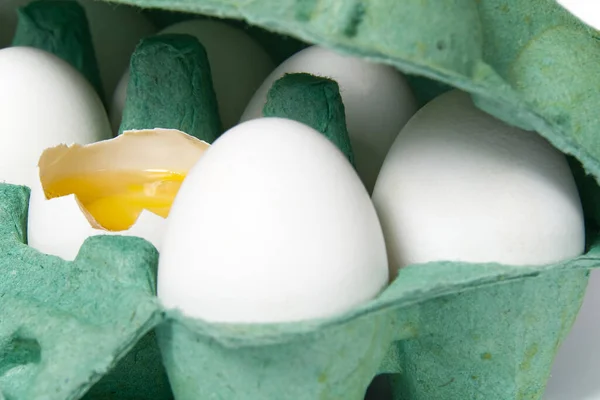 Green Paper Egg Tray with white eggs. chicken white eggs close up. broken chicken white egg.