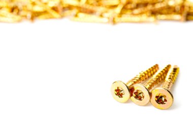Gold screws scattered randomly on a white background. Torx yellow zinc head screws