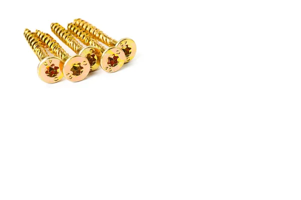 Gold screws scattered randomly on a white background. Torx yellow zinc head screws — Zdjęcie stockowe