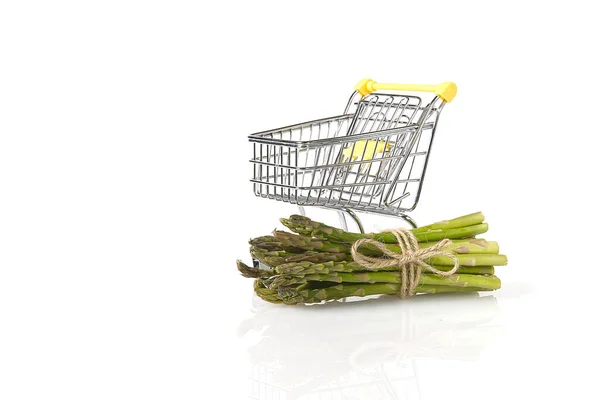 Espargos verdes frescos no carrinho de compras isolados sobre fundo branco — Fotografia de Stock