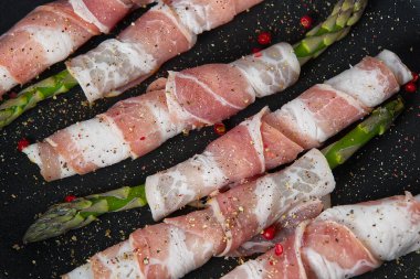 Kızartma tavasında kuşkonmaz etrafında lezzetli pastırma. Taze kuşkonmaz hazır, yemek için hazır. Sağlıklı yemek tarifleri kavramı