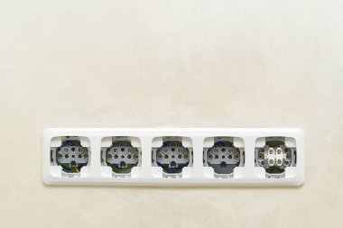 Bej duvar kapağında beyaz prizler var. kopyalama alanı. Standart elektrik prizleri.