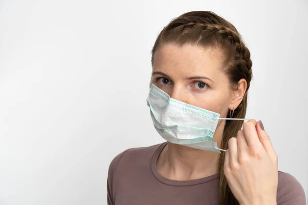 Взрослая женщина надевает защитную маску на рот, чтобы защитить себя от вирусных заболеваний и бактерий. хирургическая маска защищает от коронавируса — стоковое фото