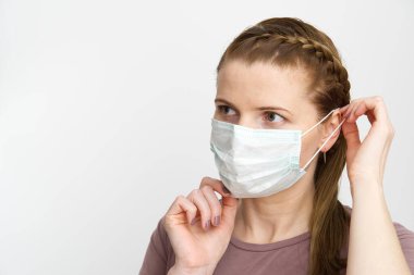 Tıbbi maske takan kadın. Maskeli kadın, grip virüsüne karşı koruma. Evde koruyucu yüz maskesi olan bir kulak. Virüsü ve salgın hastalıkları durdurun. Coronavirüsü durdurun..