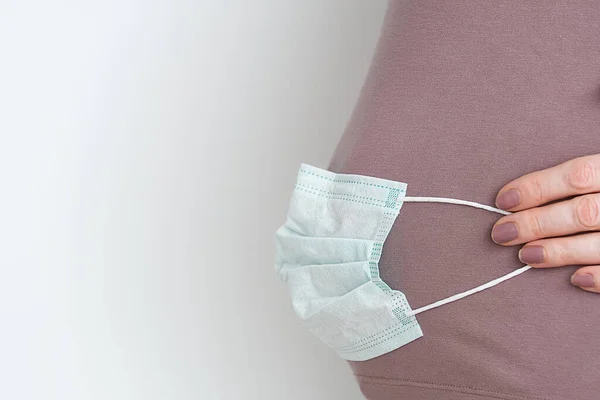 Karnında cerrahi maske olan hamile bebek Covid-19 virüsünden ya da Coronavirus salgınından korunmak için. Corona virüs salgınını durdurun. sağlıklı çocuk kavramı
