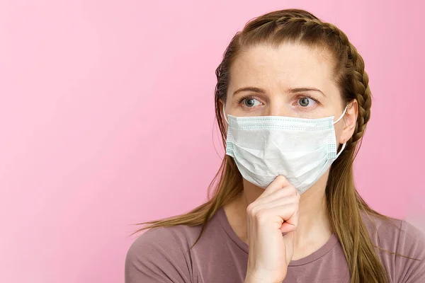 Женщина в медицинской маске. Женщина в маске - защита от вируса гриппа. ухо с защитной маской для лица дома. Остановить вирус и эпидемические заболевания. остановить коронавирус. на розовом фоне . — стоковое фото