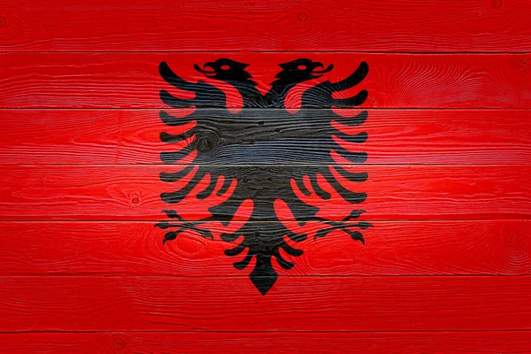 알바니아의 국기는 오래 된 나무 널빤지 배경 위에 그려졌다. 자연광 매듭 이 있는 나무 도마 질감을 닦았다. 알바니아의 목조 질감 배경 깃발. — 스톡 사진