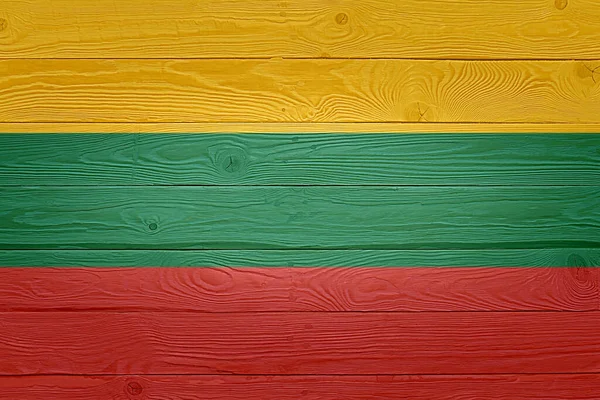 古い木板の背景にリトアニア国旗が描かれている。自然光をブラッシング木製の板の質感を結びました。リトアニアの木の質感の背景フラグ. — ストック写真