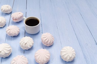 Günaydın pankart. Bir fincan kahve ve ev yapımı tatlı zephyr, açık mavi ahşap arka planda Zefir. Üst Manzara. Fotokopi alanı olan yiyecek fotoğrafçılığı.