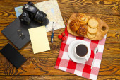 lehká snídaně, čerstvé pečivo a káva, na starém dřevěném stole. turistický koncept. Cestovní blogger snídaně budování trasy plán s šálkem kávy.