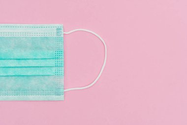 Yüz kalkanı, FFP1 NR seviyesi. Bakterilere karşı koruma, COVID-19, virüsler, koronavirüs. Tıbbi yüz maskesi N95 pembe arka planda izole edildi