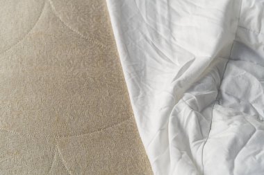 Sabah uyandıktan sonra dağınık bir çarşafın üzerindeki kırışıklıkların en üst görüntüsü. Yatak temizleme, temiz yatak konsepti.