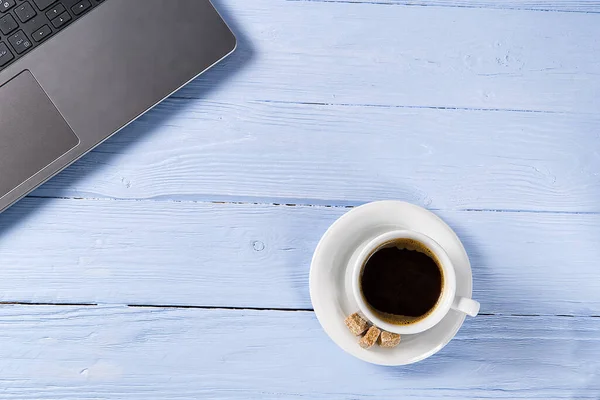 밝고 파란 오래 된 나무 탁자 위에 커피 한 잔을 올려 놓았습니다. 집 사무실에 신선 한 커피가 담긴 노트. 가정 에서의 개념 에서의 일 — 스톡 사진