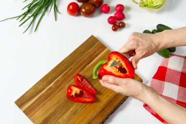 Masadaki tabakta taze sebzelerden yapılmış salata. Sebzeli ve sebzeli bir kase salata. Sebze salatası hazırlayan kadınlar. Yakın çekim. Ev mutfağı. Vejetaryen yemeği..