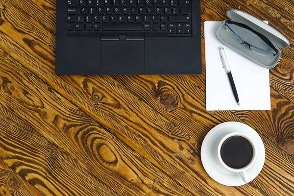 Laptop com xícara de café na velha mesa de madeira marrom. Top vista para Notebook com xícara de café fresco no escritório em casa na aldeia . — Fotografia de Stock