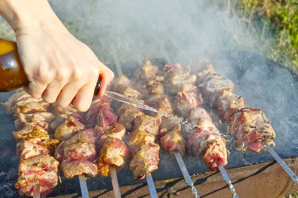 Cocinar shashlik marinado en pincho de metal en la parrilla. Fondo de fiesta patio trasero. cocinar cerdo en pinchos. Barbacoa al carbón — Foto de Stock