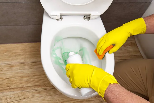 Άνθρωπος που καθαρίζει wc. Οικονόμος ως καθαριστής στην τουαλέτα. Βουρτσίστε την τουαλέτα για καθαριότητα και υγιεινή. Καθαρίζοντας λεκάνη τουαλέτας. Έννοια υπηρεσιών καθαρισμού — Φωτογραφία Αρχείου