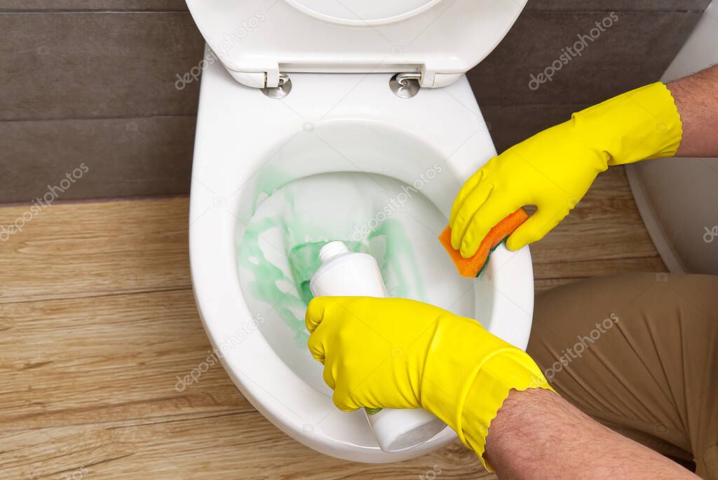 man cleaning wc. Housekeeper as a cleaning man at the toilet. Brush up Toilet for cleanliness and hygiene. cleaning toilet bowl. Cleaning service concept