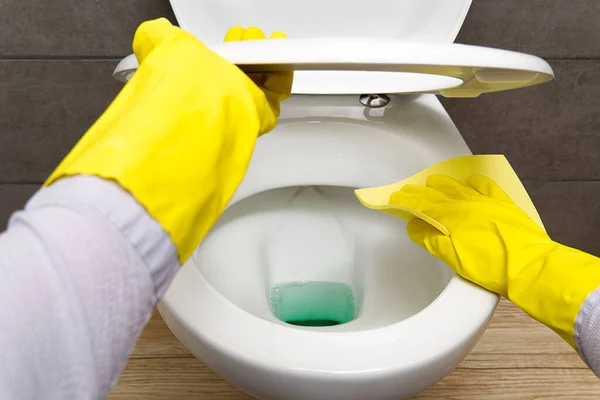 Άντρες με κίτρινα γάντια καθαρίζουν λεκάνες τουαλέτας. έννοια οικιακού καθαρισμού. — Φωτογραφία Αρχείου
