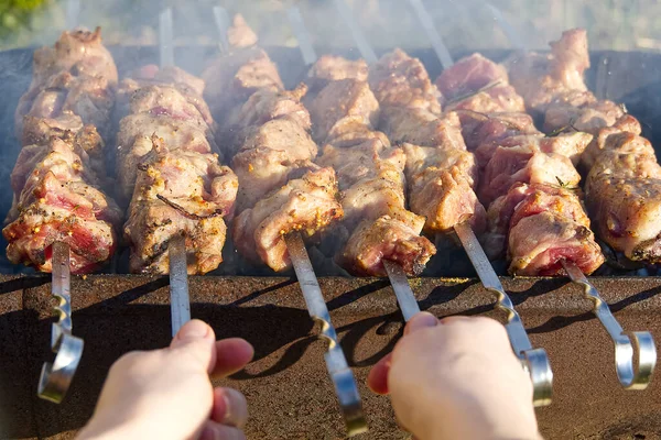 Izgaradaki metal şişte terbiye edilmiş shaşlik pişiriyorum. Arka bahçe partisi geçmişi. Şişte domuz eti pişirmek. Kömür üzerine barbekü — Stok fotoğraf