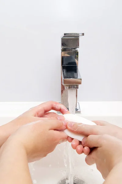 Niños lavándose las manos con jabón bajo la grúa con agua. Primer plano. concepto de higiene personal — Foto de Stock