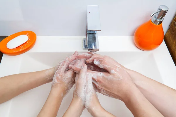 Kinder waschen sich unter dem Kran mit Wasser die Hände mit Seife. Nahaufnahme. Persönliches Hygienekonzept — Stockfoto