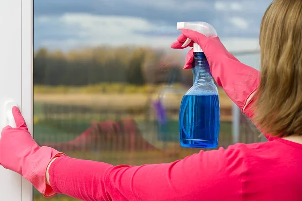 Window cleaning. A woman in pink rubber gloves washes a window in a house. Happy Woman In Gloves Cleaning Window. Concept for home cleaning services — Stock Photo, Image