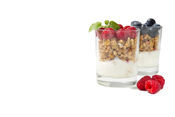 Postre muesli con yogur y arándanos en un vaso sobre fondo blanco. Granola en vaso con bayas y yogur . — Foto de Stock