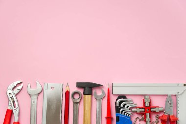 Ev bakımı, servis, diy konsepti. Ahşap, metal ve diğer inşaat işleri için aletler. DIY araçlarının üst görünümü. Ev tamiri. pembe arkaplanda.