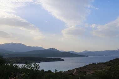 Dağlı ve bulutlu deniz manzarası.