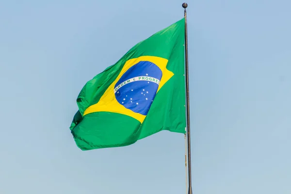 Brazilian flag flying with blue sky background — 스톡 사진