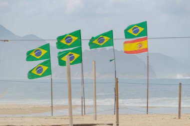 Brezilya 'nın Rio de Janeiro plajındaki Copacabana plajında bir sürü Brezilya bayrakları ve İspanya bayrakları var..