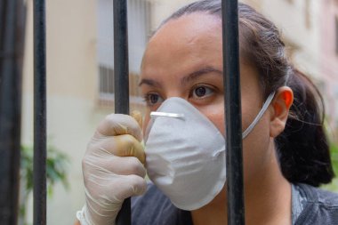 Rio de Janeiro 'da koronavirüs karantinası sırasında maske ve eldiven takan beyaz kadın..