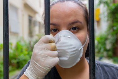 Rio de Janeiro 'da koronavirüs karantinası sırasında maske ve eldiven takan beyaz kadın..