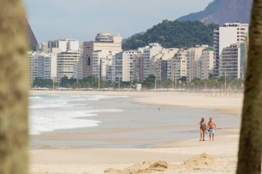 Rio de Janeiro, Brezilya 'daki Coronavirus salgını sırasında boş Copacabana sahilinde yürüyen çift - 19 Nisan 2020: Rio de Janeiro Brezilya' daki Coronavirus salgını sırasında boş copacabana sahilinde yürüyen çift.