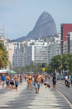 Rio de Janeiro, Brezilya 'daki koronavirüs salgını sırasında Copacabana sahil yolunda yürüyen insanlar - 19 Nisan 2020: Rio de Janeiro' daki koronavirüs salgını sırasında kopacabana kaldırımında yürüyen insanlar.