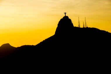 Kurtarıcı İsa 'nın silueti Rio de Janeiro, Brezilya' da güzel bir günbatımı ile 23 Aralık 2015: Kurtarıcı İsa 'nın silueti Rio de Janeiro' da gün batımında güzel turuncu bir gökyüzü ile birlikte.