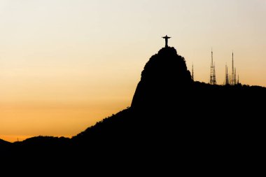 Kurtarıcı İsa 'nın silueti Rio de Janeiro, Brezilya' da güzel bir günbatımı ile 23 Aralık 2015: Kurtarıcı İsa 'nın silueti Rio de Janeiro' da gün batımında güzel turuncu bir gökyüzü ile birlikte.