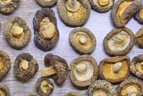 BACKGROUND with mushrooms, rich texture of the material, on the table a light brown tone, form a recognizable wood relief