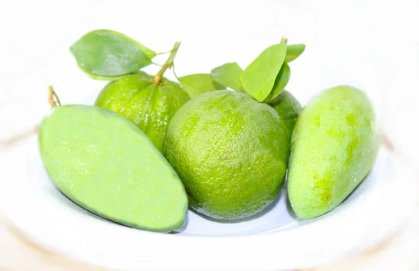 Grüne Mangofrüchte Orangen Auf Einem Zweig Mit Blättern Einem Teller — Stockfoto