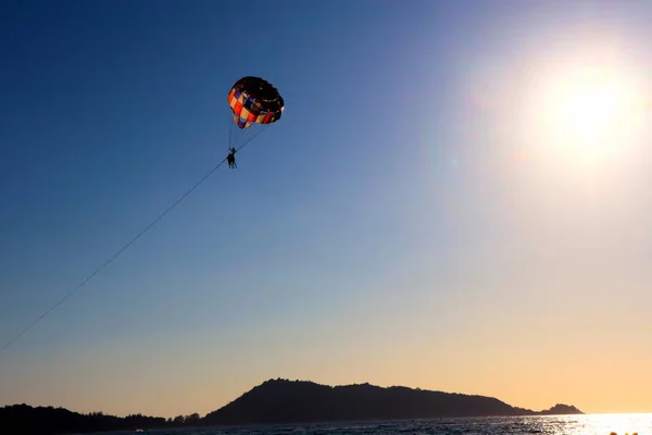 ビーチでのスポーツ 空と太陽に向かって飛んでパラシュート — ストック写真