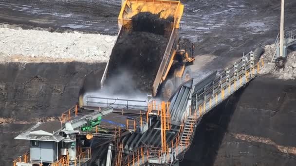 Caminhões basculantes de construção pesada despejar carvão para o transportador na mina de carvão — Vídeo de Stock