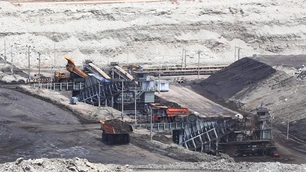 Тяжелые строительные самосвалы сбрасывают уголь на конвейер на угольной шахте — стоковое видео