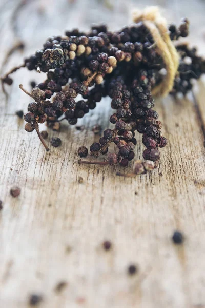 Tak van zwarte peper droog op houten tafel, specerijen voor voedsel. — Stockfoto