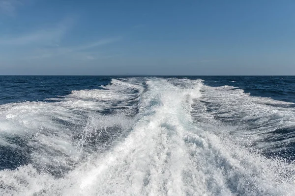 Arka plan su yüzeyine hızlı hareketli Motorlu tekne arkasında