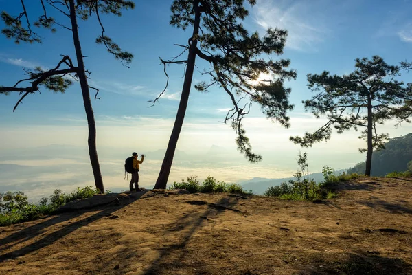 Reisender entspannt sich auf dem Felsen und trinkt Mineralwasser — Stockfoto